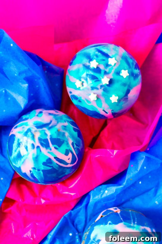 Overhead close-up shot of the finished Galaxy Hot Chocolate Bombs recipe, showcasing vibrant colors and sprinkles.