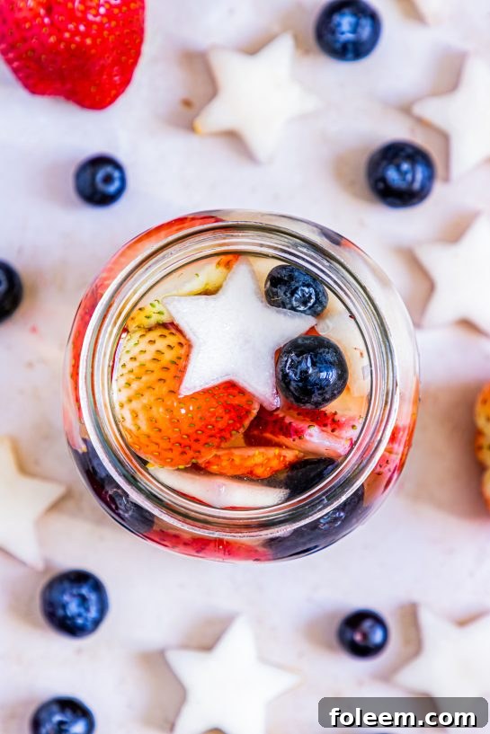 Overhead shot of my Patriotic Sangria recipe to enjoy a cocktail while beating the heat at the same time! With fresh blueberries, strawberries, white grape juice, brandy, and wine, it's perfect for 4th of July or Memorial Day!