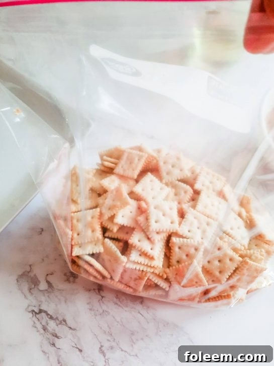 Saltine crackers evenly spread out inside a zip-top bag after oil has been added.