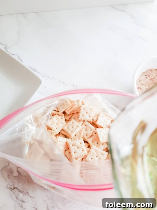 Pouring the liquid seasoning mixture over the crackers in a zip-top bag.