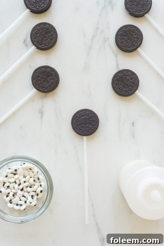 Oreo cookies with lollipop sticks inserted, ready for the mummy glaze.