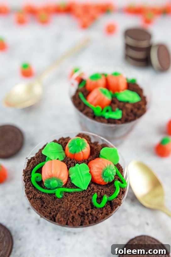 Cute Pumpkin Patch Dirt Cups with chocolate pudding, Oreo crumbs, and candy pumpkins for fall celebrations