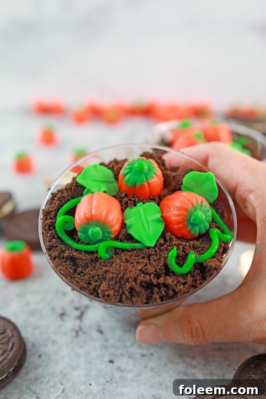 Another perspective of the adorable Pumpkin Patch Dirt Cups, showcasing the vibrant candy pumpkins and green decorations