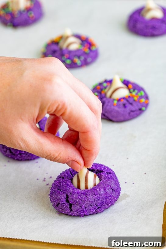 Close-up of adorable peanut butter witch hat cookies with purple sprinkles and chocolate kiss hats.