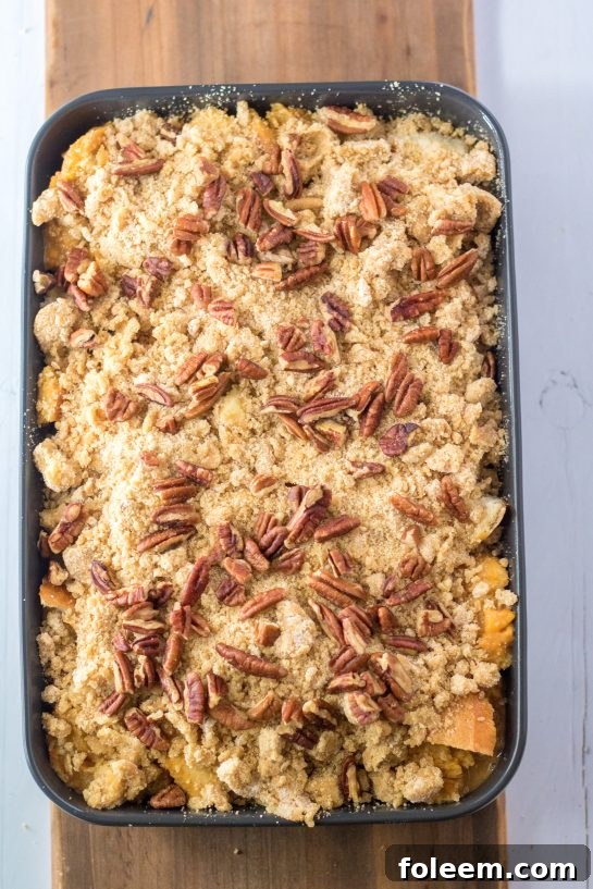 The Sweet Potato French Toast Casserole, assembled and ready, covered with its delightful crumb topping and pecans, poised to enter the oven for baking.