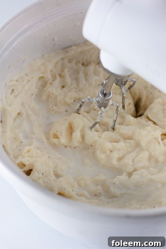 Mixing potatoes for the Country creamy Amish Mashed Potatoes Recipe