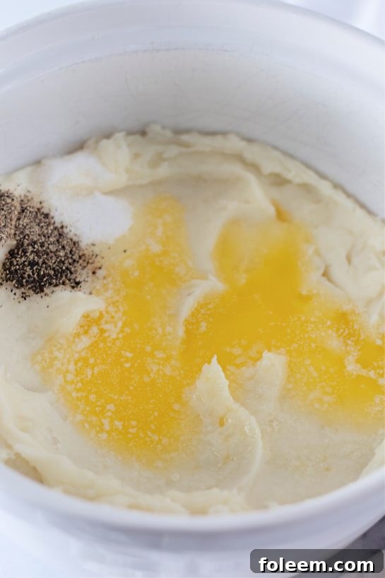 Pouring browned butter over potatoes for Amish mashed potatoes