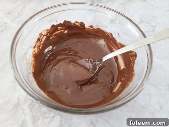 Melting chocolate chips in a bowl, a crucial step for making Mocha Hot Chocolate Bombs.