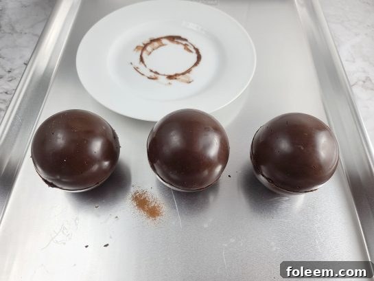 Sealing two chocolate half-spheres together to form a complete Mocha Hot Chocolate Bomb.