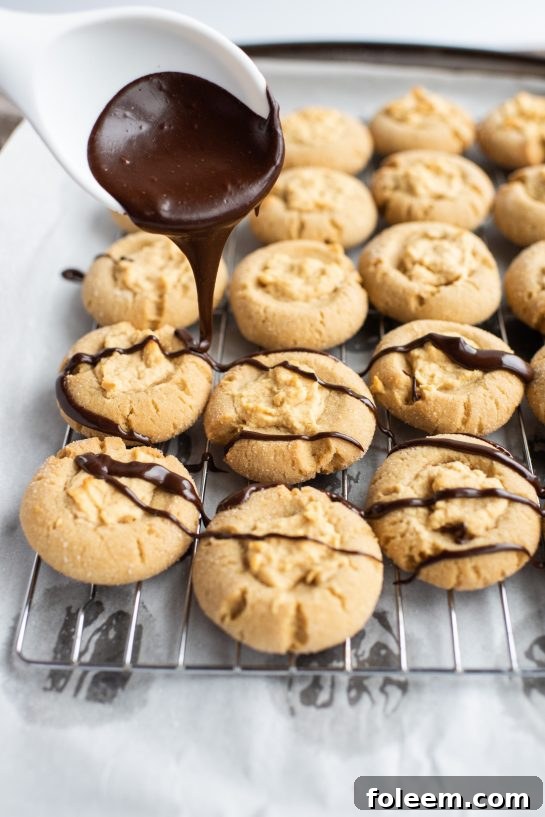 Drizzling the chocolate ganache for the Peanut Butter Thumbprint Cookies recipe 