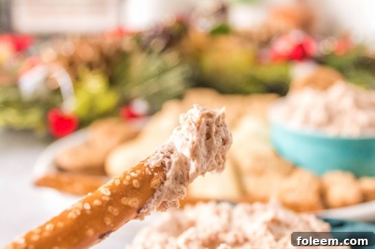 Dipping pretzels in the Cinnamon Roll Dip recipe for Christmas or holiday dessert