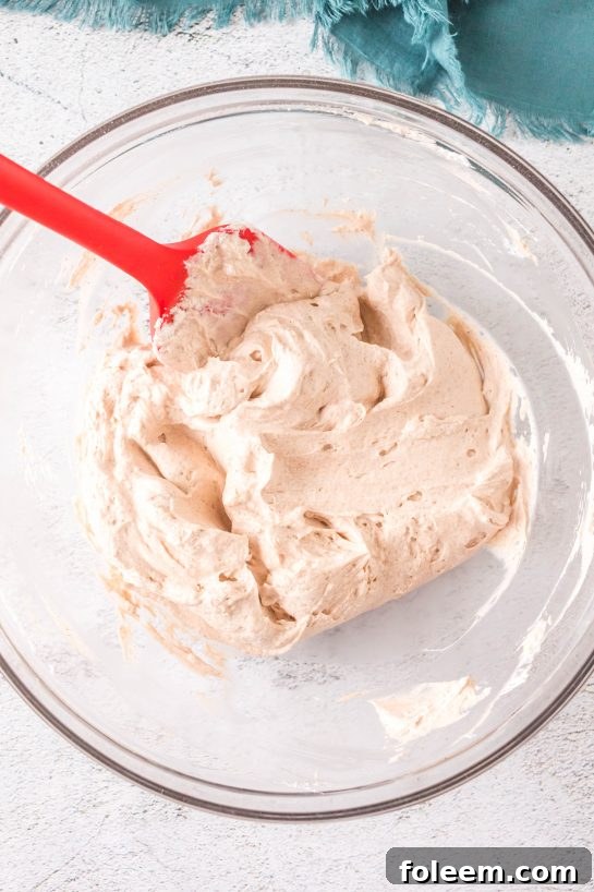 Cream cheese being mixed to make this easy Cinnamon Roll Dip recipe