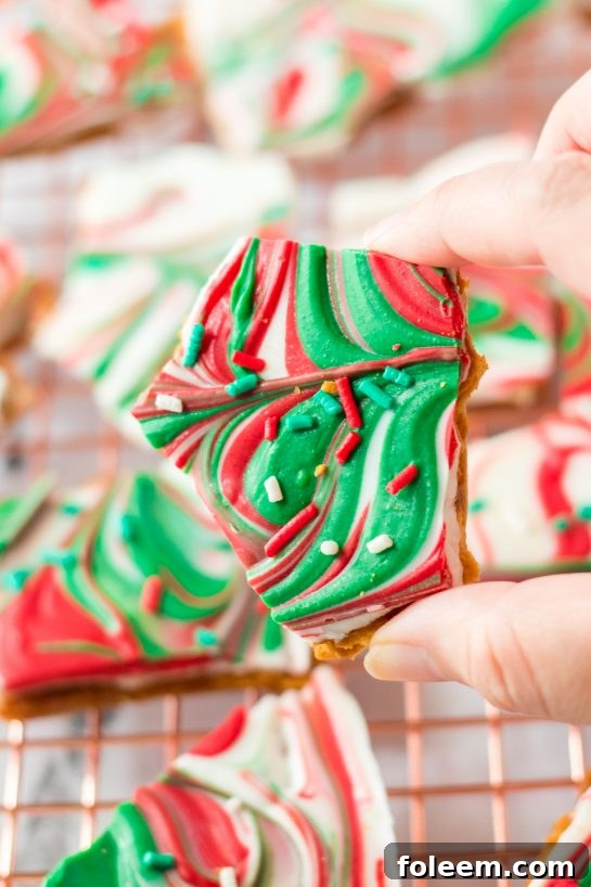 Close-up view of festive Christmas Ritz Cracker Candy pieces, coated in white chocolate and colorful sprinkles, perfect for holidays.