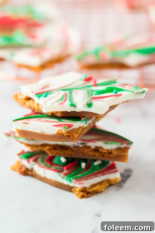 Stack of finished Christmas Ritz Cracker Toffee pieces, showcasing the layers of cracker, toffee, and chocolate.