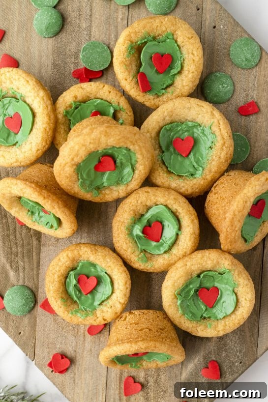 Festive green Grinch Cookie Cup Bites adorned with a small red heart, ready for holiday celebrations.