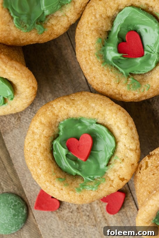 Close-up of a single Grinch Cookie Cup Bite, showcasing its green center and red heart.