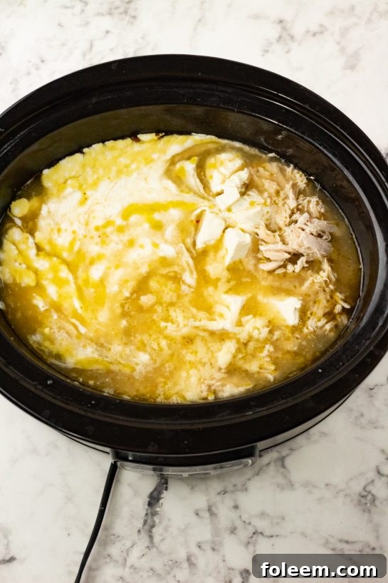Chicken and all ingredients placed in slow cooker for Crock Pot Green Chili Chicken Enchilada Soup