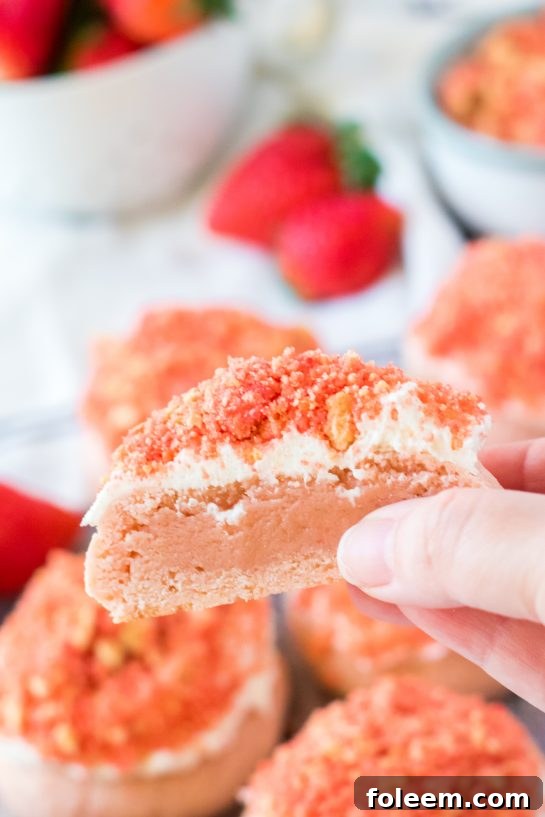 Close-up of a Strawberry Crunch Cookie with pink frosting and sprinkles, ideal for Valentine's Day desserts.