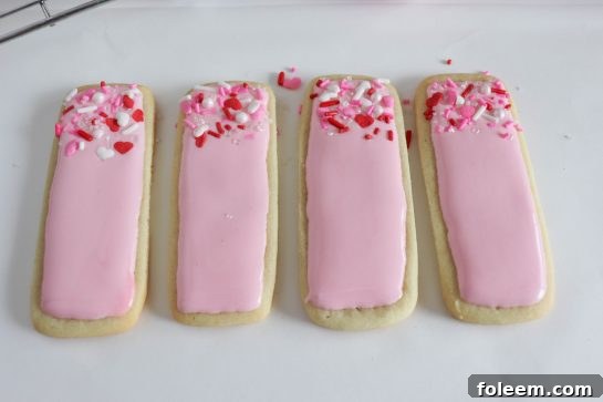Photo of applying the easy sugar cookie royal icing recipe to the sugar cookies for any holiday or party