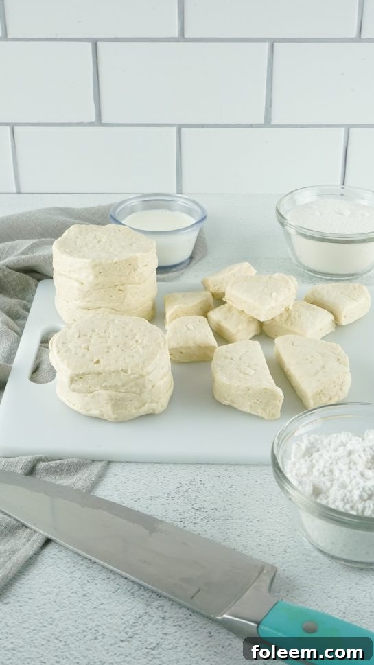 Pillsbury biscuits being quartered for easy slow cooker monkey bread preparation.
