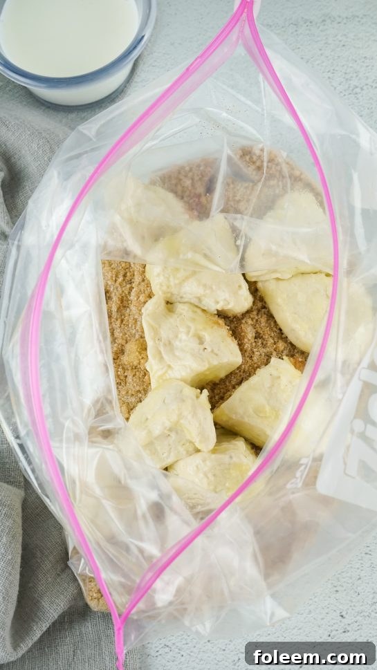 Biscuit pieces coated in cinnamon sugar mixture, ready for the slow cooker.