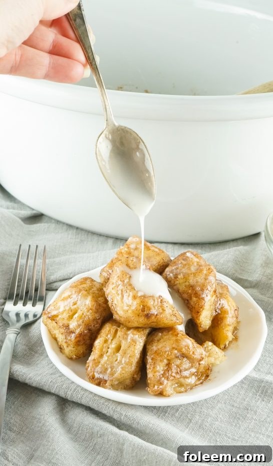 Close-up of fluffy and sweet slow cooker monkey bread, drizzled with glaze.