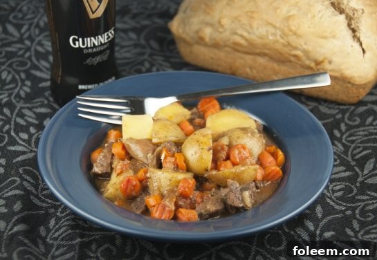 Guinness Irish Beef Stew Recipe for St. Patrick's Day, served in a rustic bowl with crusty bread.