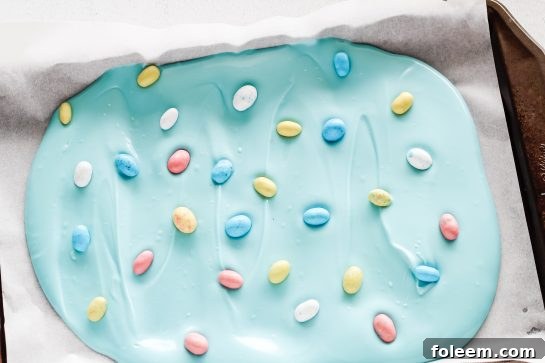Placing the Robin Eggs onto the blue melting chocolate discs for the No-Bake Robin Egg Easter Bark recipe 