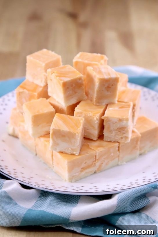 Close-up of vibrant Orange Creamsicle Fudge squares, showcasing their creamy texture and orange swirl.