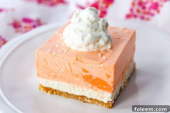 A tray of Orange Creamsicle Dream Bars with a cookie crust, vanilla cheesecake layer, and an orange cream topping.
