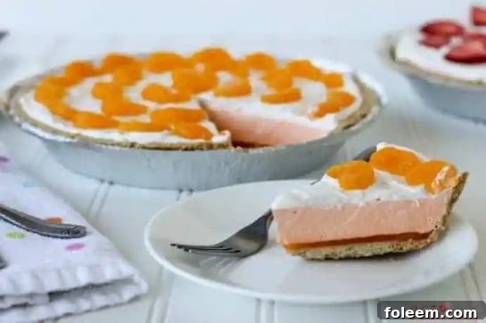 A slice of creamy Orange Creamsicle Pie on a plate, showing its vibrant orange and white layers.