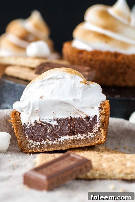 No campfire needed for these S’mores Cookie Cups: graham cracker cookies filled with Hershey's chocolate ganache, topped with toasted homemade marshmallow fluff.