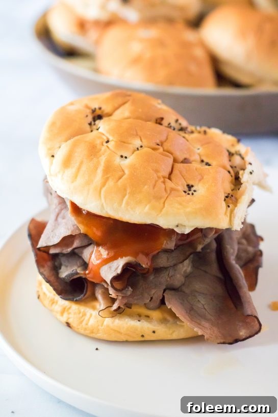 Detailed view of the assembly process for a homemade Arby's Beef & Cheddar sandwich.