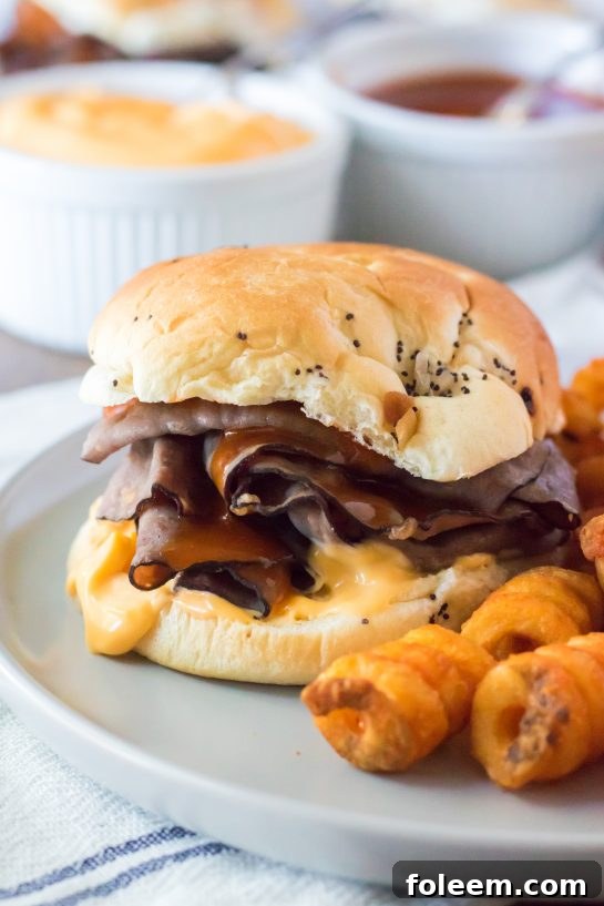 The best copycat Arby's Beef & Cheddar recipe, featuring a close-up of the saucy, meaty sandwich on an onion bun.