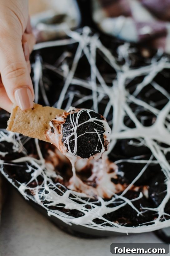 Easy and spooky Spiderweb S'mores Dip recipe presented beautifully, showing the texture of the white chocolate and toasted marshmallows, ideal for Halloween celebrations