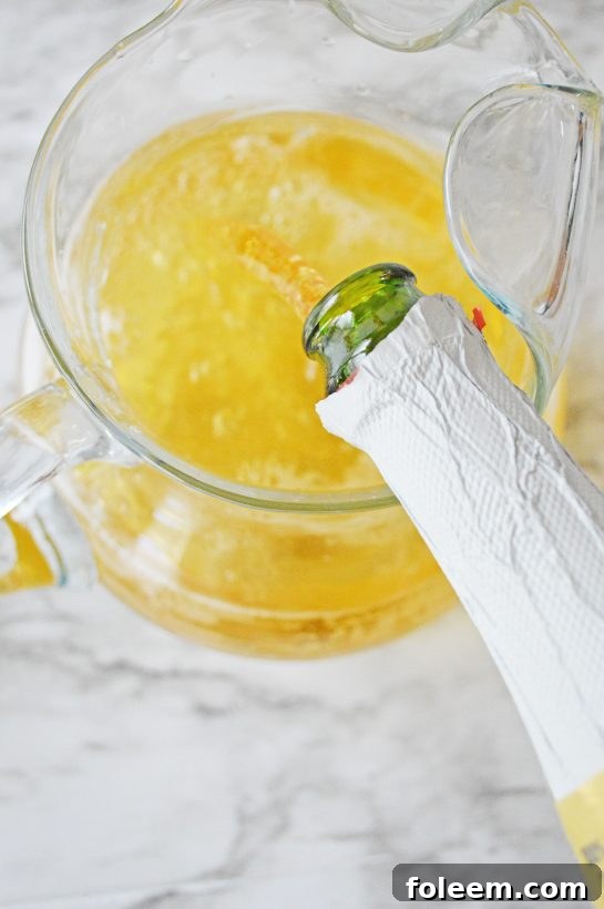 Pouring white wine into a pitcher with pumpkin sangria ingredients for a festive autumn drink