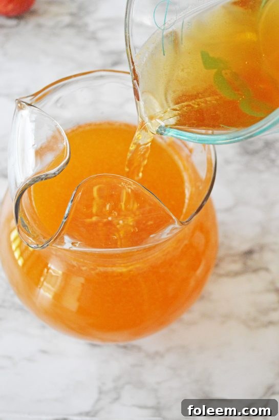Mixing all ingredients in a large pitcher, preparing the pumpkin sangria for serving at a fall party