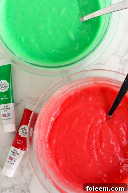 Mixing vibrant red and green gel food coloring into separate bowls of cake batter for a festive Christmas Cake Roll.