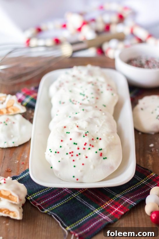 Finished No-Bake Polar Bear Claws, a delicious holiday dessert coated in white chocolate with festive sprinkles.