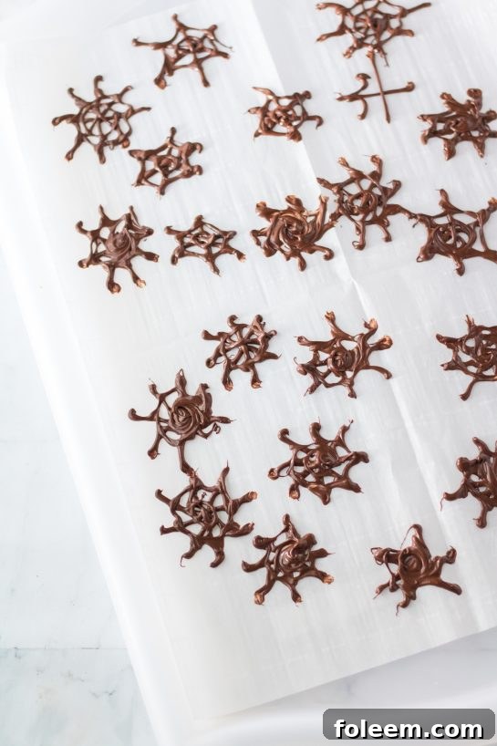 Step-by-step guide to making delicate chocolate spiderwebs for your Halloween Jello Shots recipe.