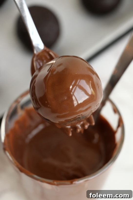 Dipping the cake balls in melted chocolate for the Easy Turkey Cake Pops recipe.