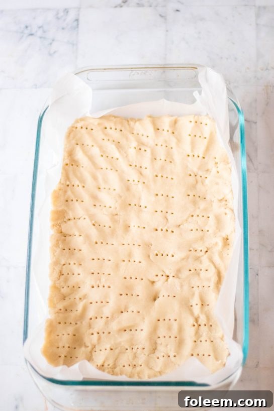 Poking the holes in the shortbread for the Valentine's Day Millionaire Bars recipe
