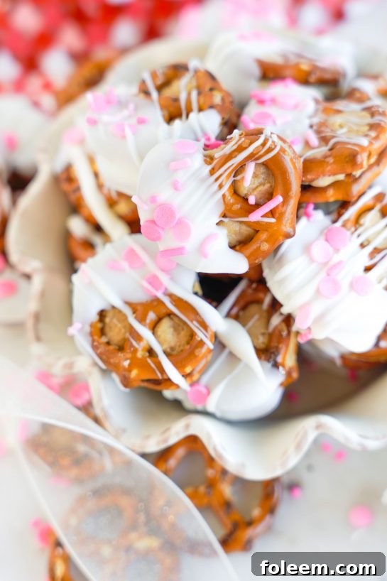 Valentine's Day Pretzel Bites recipe is so easy to make for any holiday, it's no wonder they're a classic! Two pretzels that are stuffed with a peanut butter filling and dipped in white chocolate coating. Great for gifts and parties!