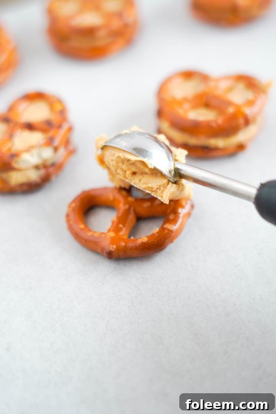 Scooping the creamy peanut butter filling onto pretzels to make delicious Valentine's Day Pretzel Bites