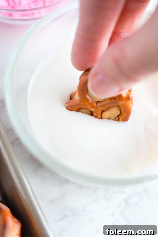 Dipping the peanut butter stuffed pretzels into melted white chocolate for Valentine's Day treats