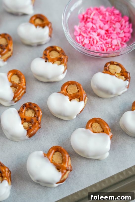 The dipped Valentine's Day Pretzel Bites ready for festive sprinkles