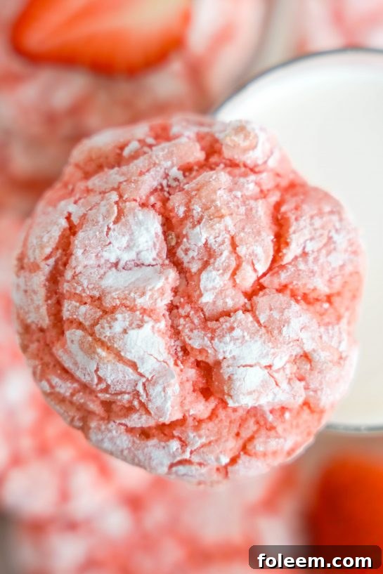 Close-up photo of the Strawberry Crinkle Cookies recipe for Valentine's Day covered in powdered sugar.