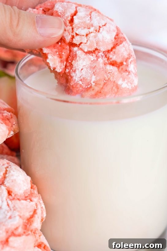 Image of dunking one of the Strawberry Crinkle Cookies in milk for Valentine's Day party