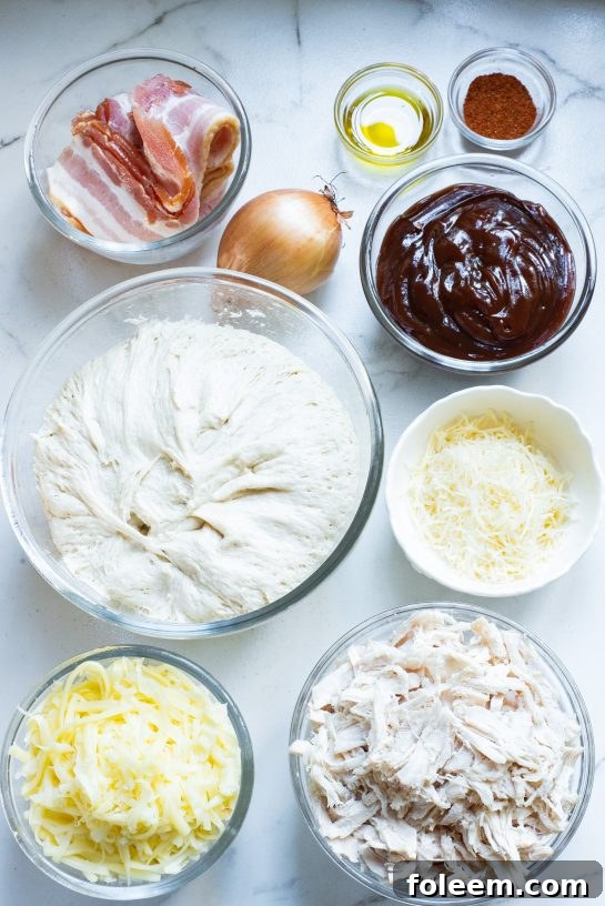 All the fresh ingredients meticulously laid out for making Sheet Pan BBQ Chicken Pizza, including chicken, BBQ sauce, cheese, and dough.