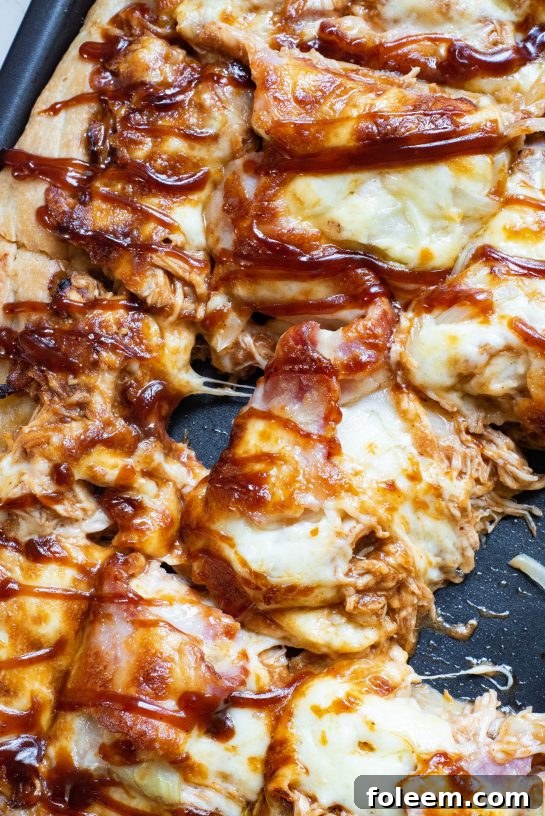 A vibrant close-up of a Sheet Pan BBQ Chicken Pizza, highlighting the rich colors of the sauce, cheese, and toppings, appealing for any occasion.
